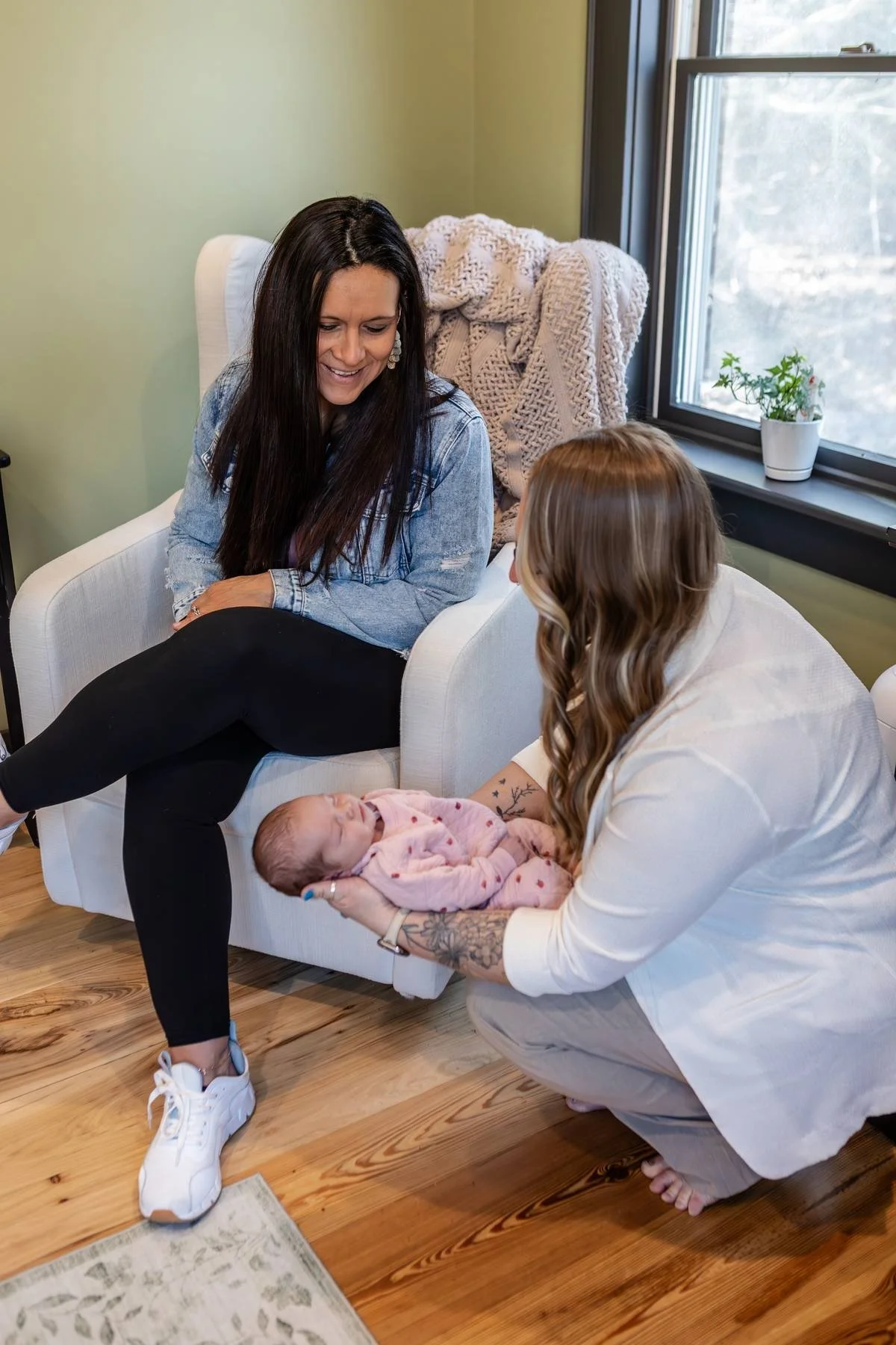 An IBCLC offering breastfeeding support to a new mother and young baby