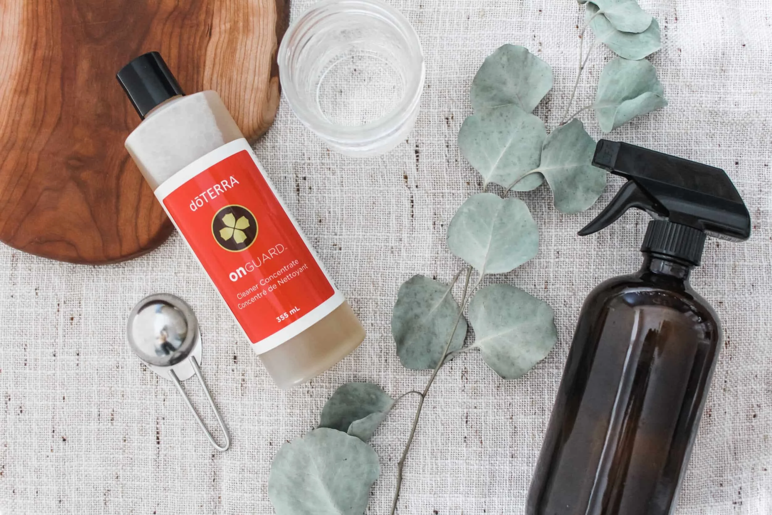 Natural cleaning supplies, including a reusable spray bottle and plant-based cleaner, for creating a healthier, non-toxic home.
