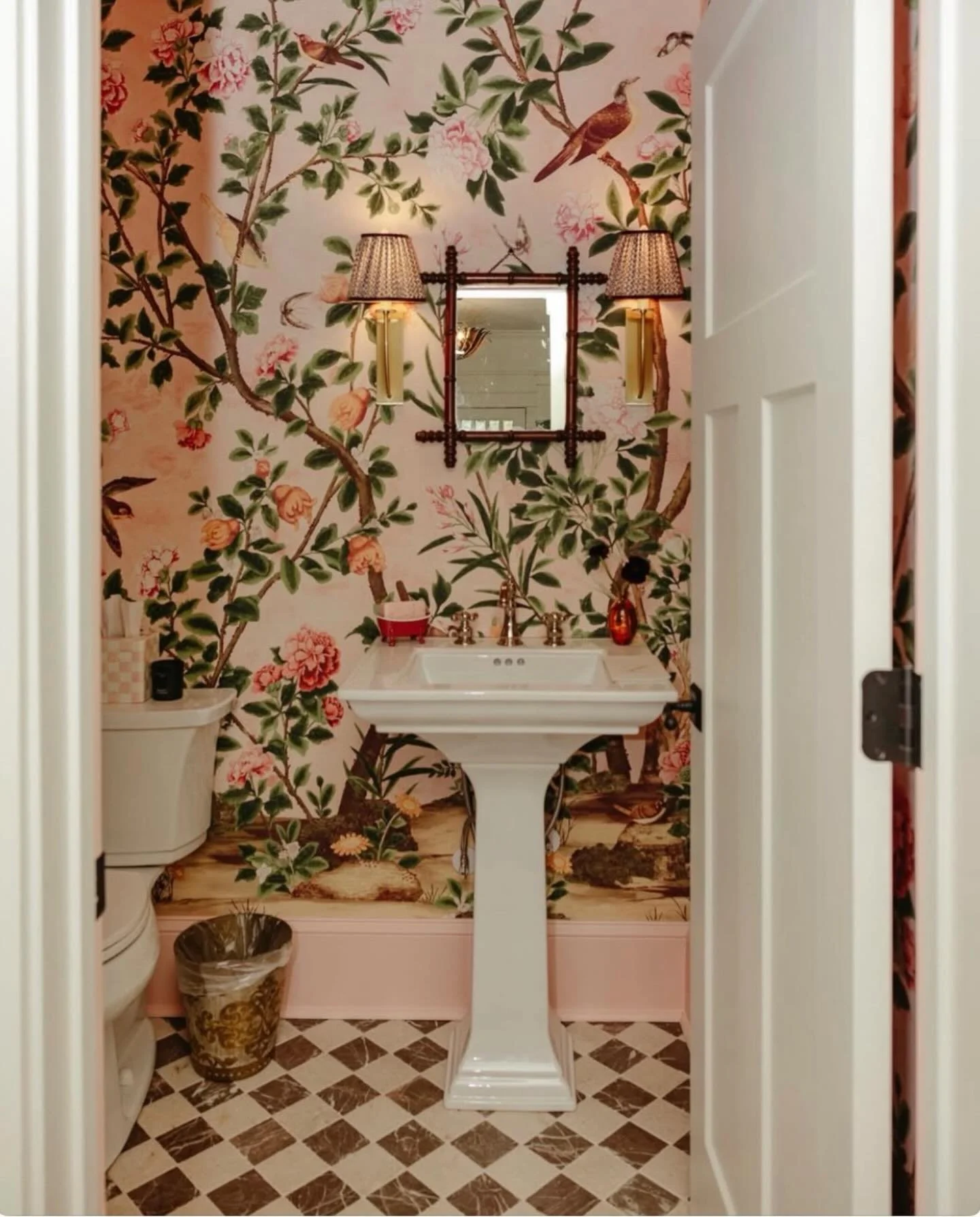 Trick the eye 👀. This designer made sure the fabulous wallpaper would capture your attention in order to disguise the toilet that is on full display. She also cleverly used a smaller mirror which lets the wallpaper be the star. Nice! 
Have a great w