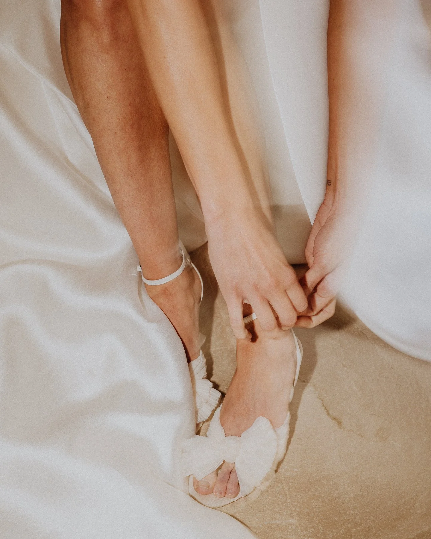 Close-up of a bride putting on her wedding shoes during bridal preparations, soft light and elegant details captured at a Mallorca destination wedding