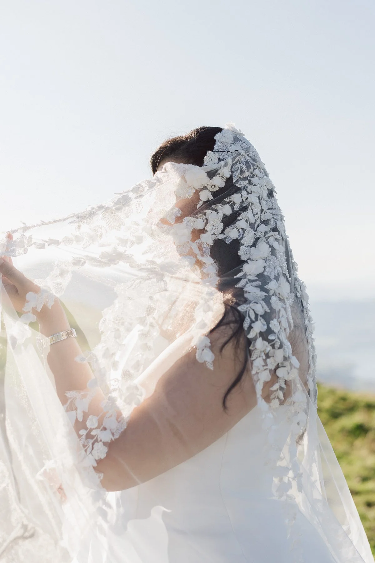 Voile de mariée en dentelle flottant au vent dans la lumière en montagne en Suisse
