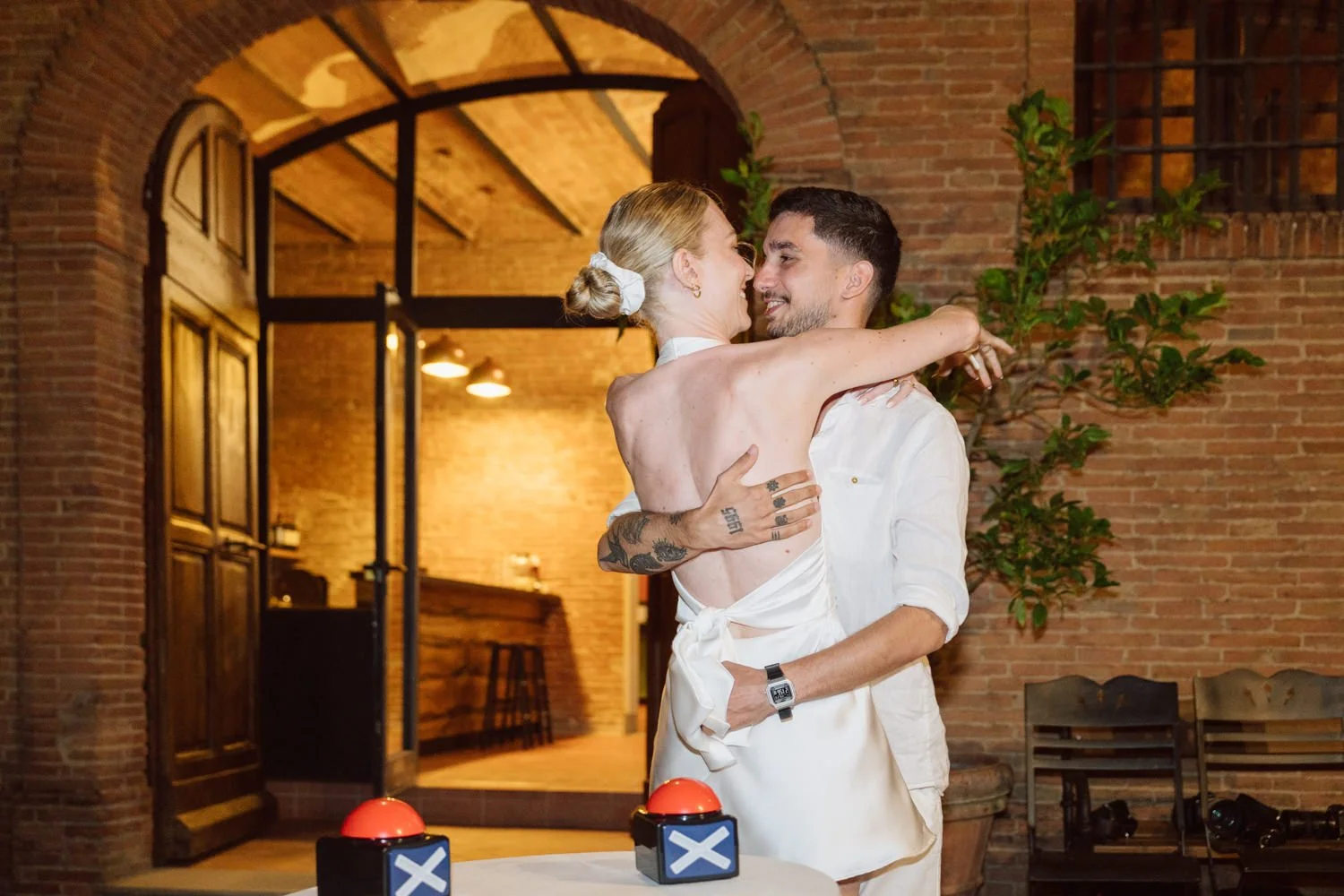 Couple de mariés enlacés lors de la soirée de mariage dans une villa en Toscane, ambiance intime et chaleureuse