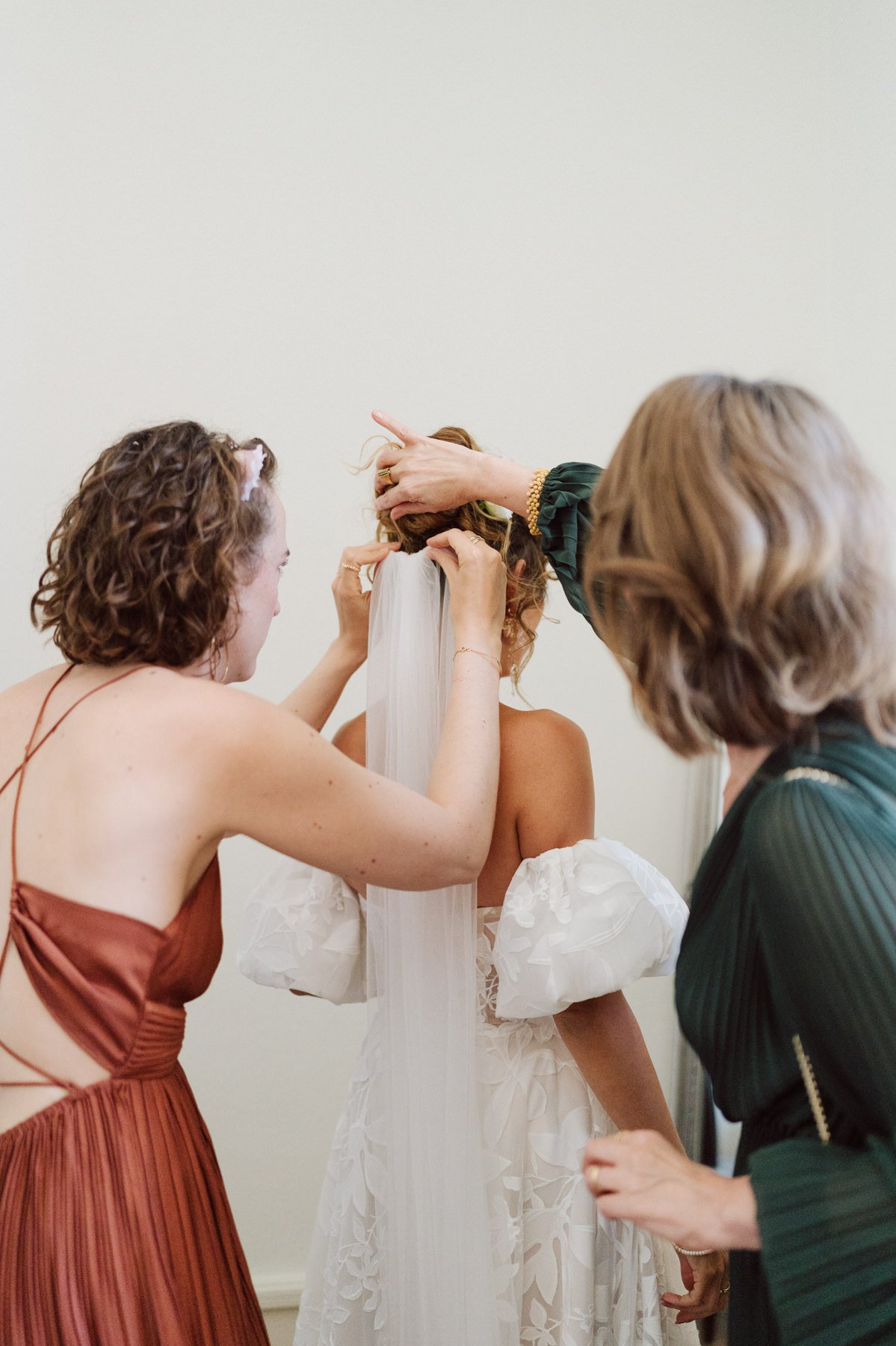 Mise en place du voile de la mariée lors des préparatifs, entourée de ses proches