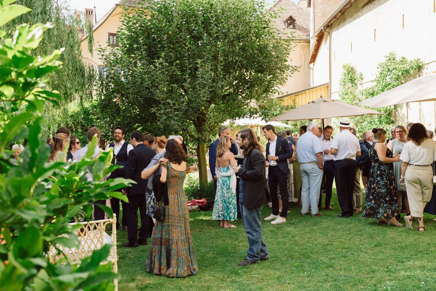 Invités réunis pour le cocktail de mariage au Jardin Baillival, ambiance estivale et conviviale dans un jardin verdoyant.