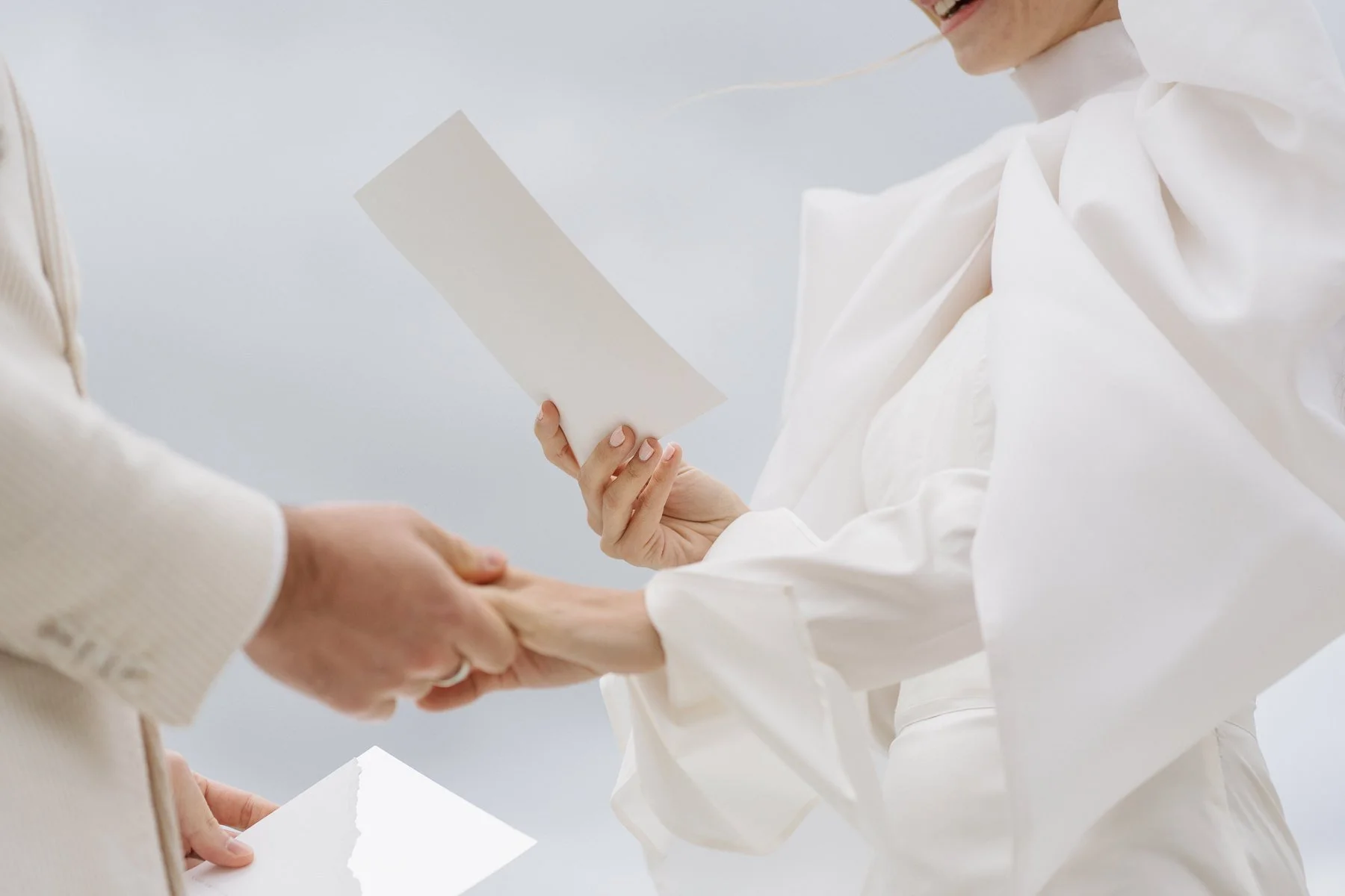 Deux personnes se serrent la main lors d'une cérémonie, avec l'une d'elles tenant une feuille de papier blanche.