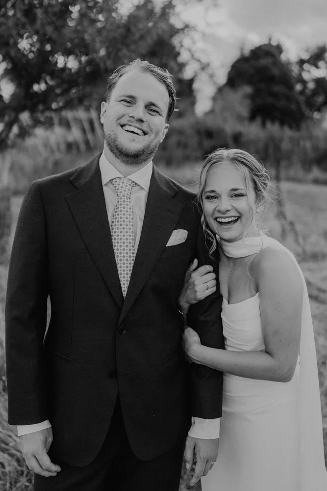 Yveline et Vincent partagent un moment spontané et complice lors de leur mariage dans le Perche. Une photographie de couple en noir et blanc, naturelle et pleine de mouvement, réalisée par Nonante Émotions, photographe de mariage en Suisse et à desti