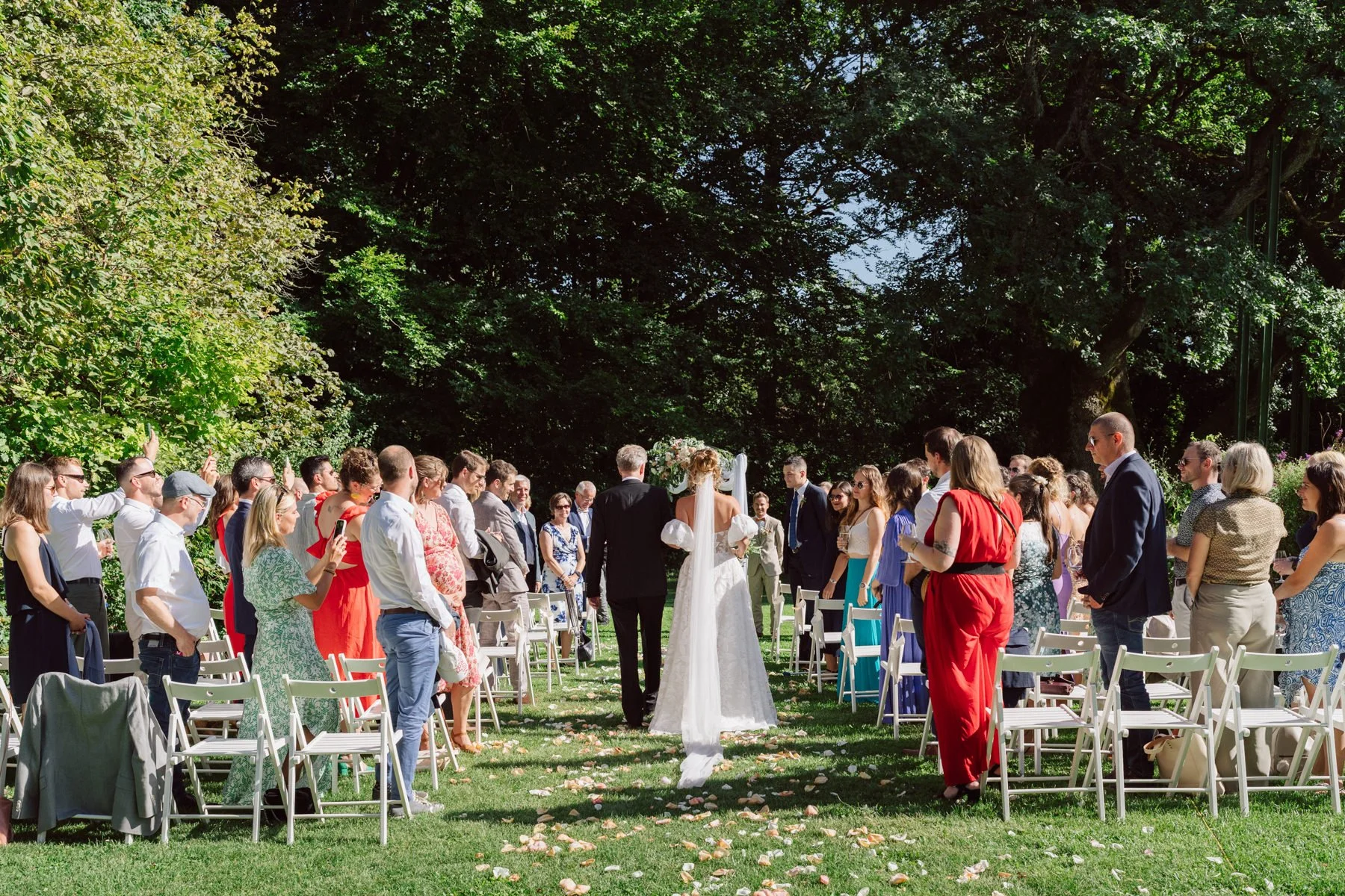 Entrée de la mariée au bas de son papa lors d’un mariage en extérieur au Castel de Bois-Genoud