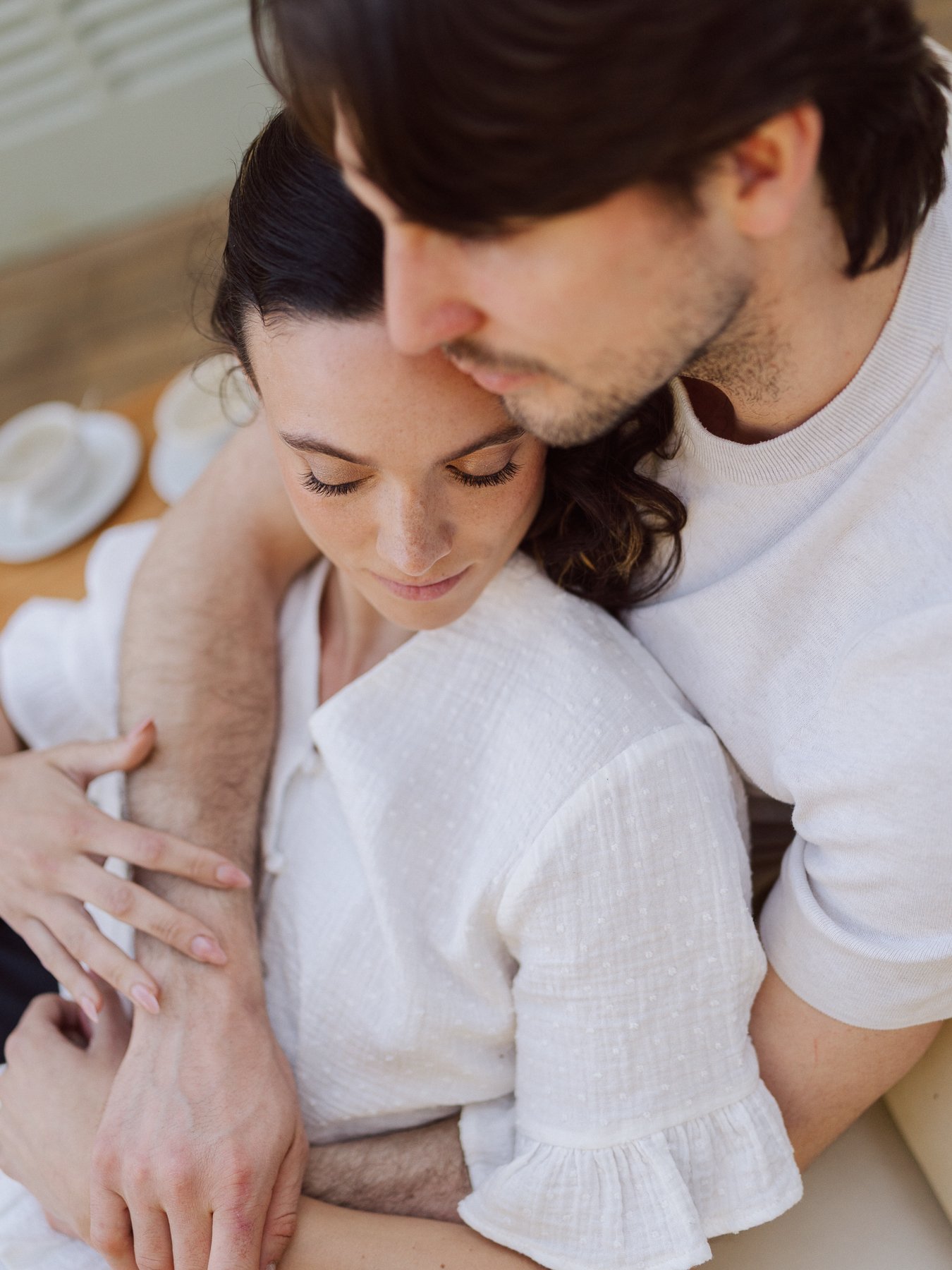 Couple enlacé en lumière naturelle lors d’une séance engagement, moment tendre et intime capturé de manière douce et authentique
