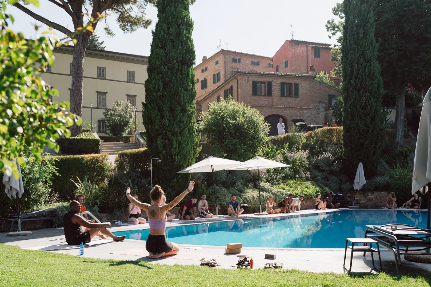 Séance de yoga au bord de la piscine d’un domaine en Toscane pendant un week-end de mariage