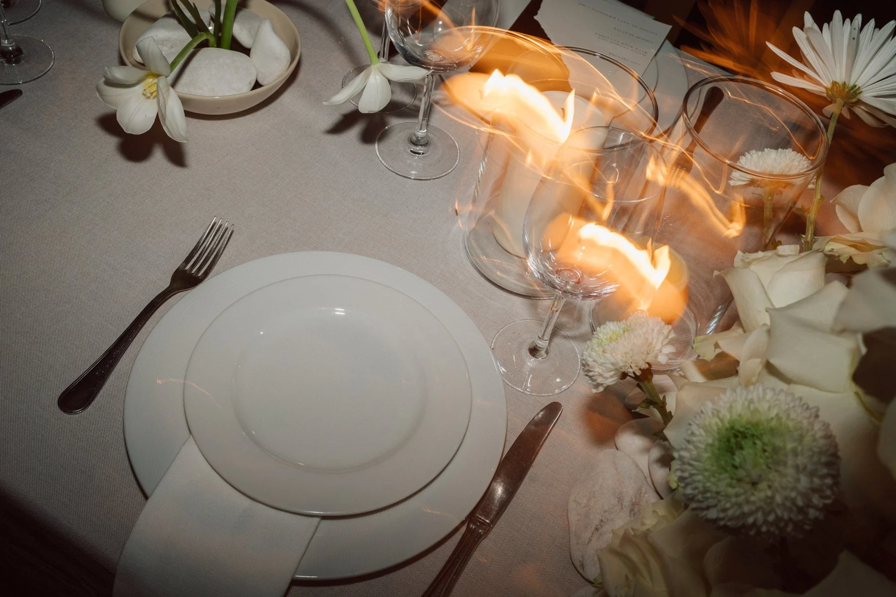 Détail de table de mariage avec bougies, fleurs blanches et vaisselle élégante lors d’une réception au Portugal – photo Nonante Emotions.