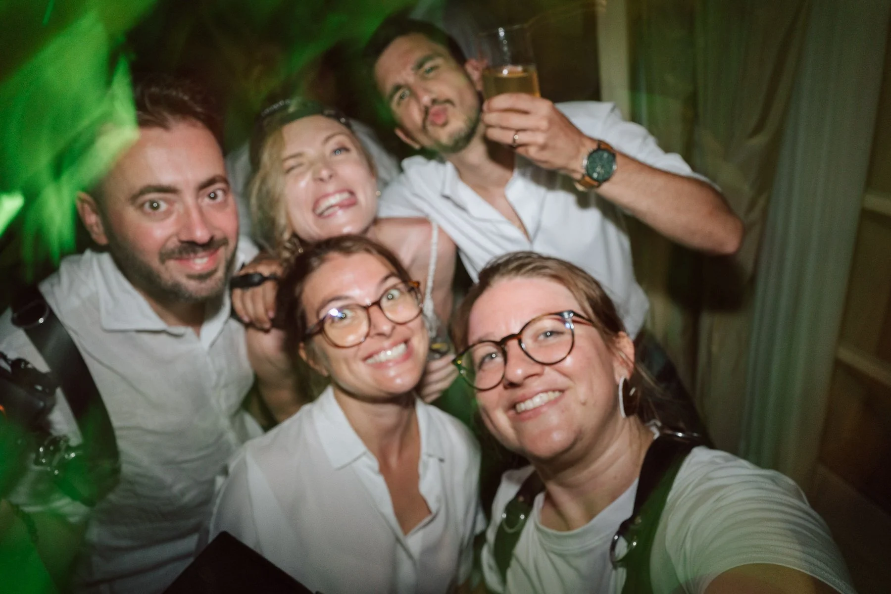 Selfie de groupe d’invités pendant la soirée de mariage en Toscane, ambiance festive et lumières de fête