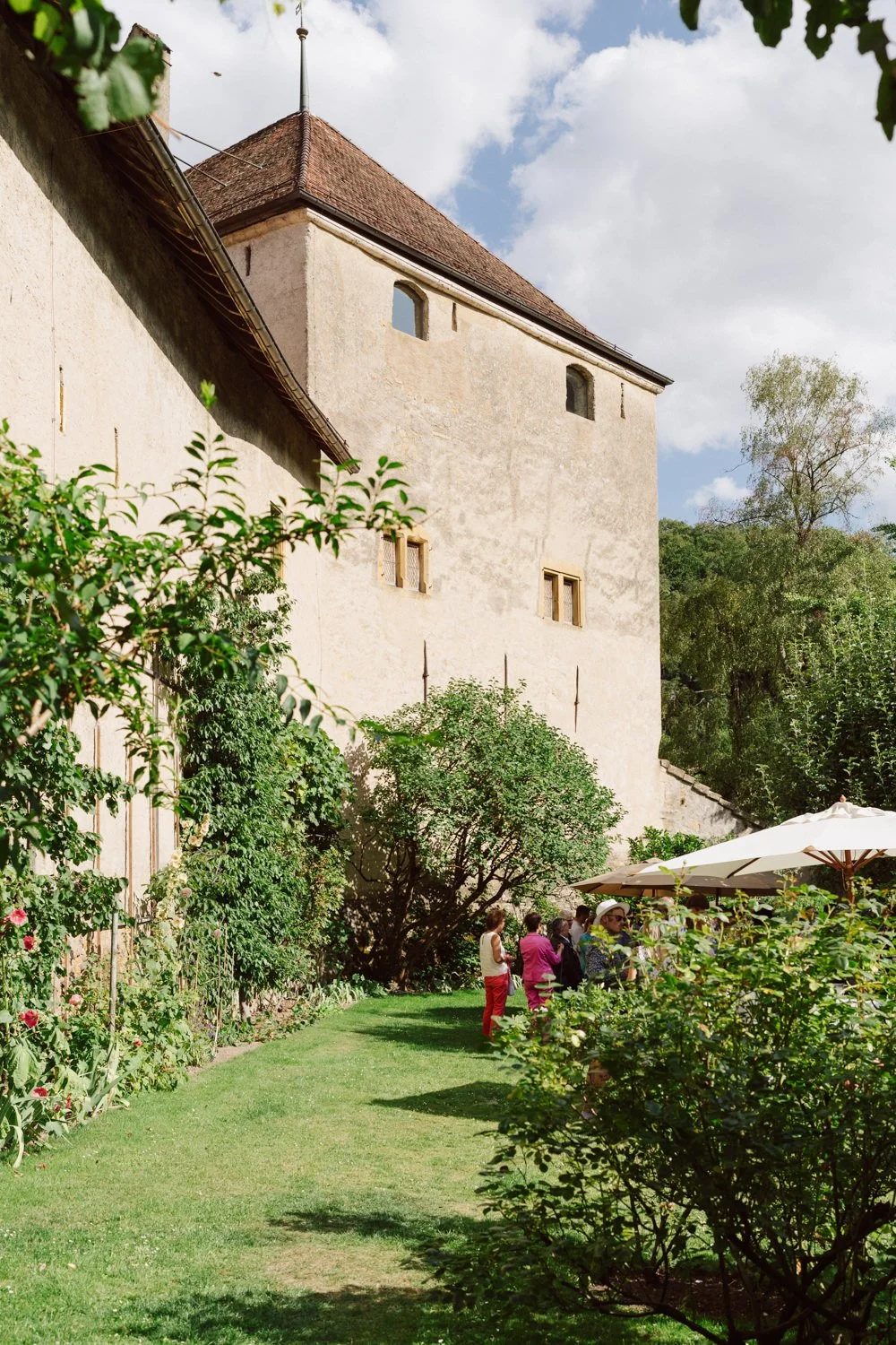 Cocktail de mariage dans le jardin du Jardin Baillival, invités réunis au pied du château, ambiance estivale et élégante.