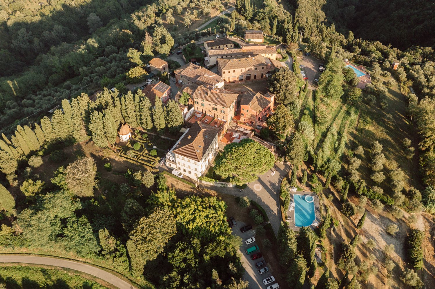 Vue aérienne d’une villa en Toscane entourée de cyprès et collines, lieu idéal pour un mariage en Italie