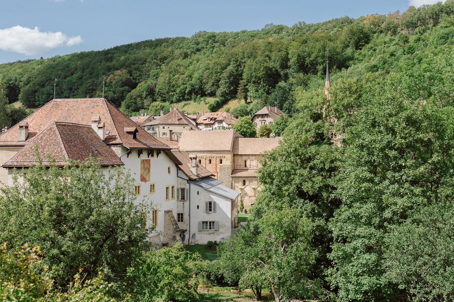 Le village de Romainmôtier niché dans la verdure, architecture historique et nature environnante, décor unique pour un mariage au Jardin Baillival, Nonante Émotions.