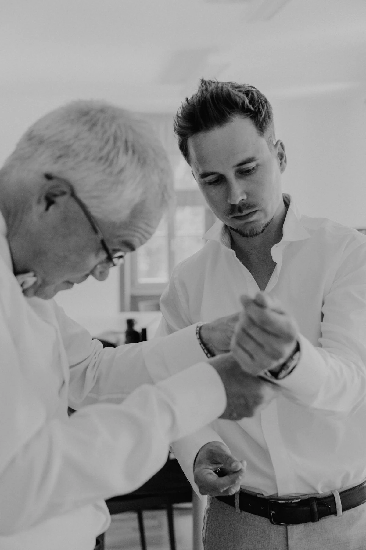 Moment de complicité entre le marié et son père lors des préparatifs de mariage au Castel de Bois-Genoud