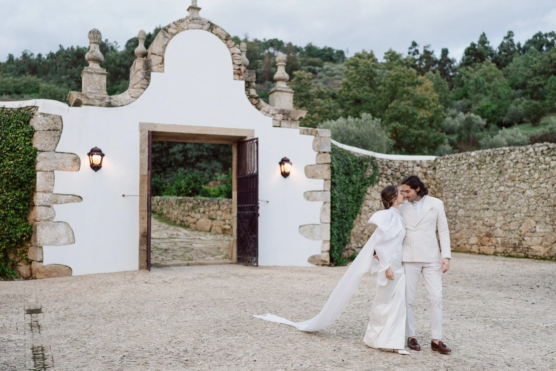 Couple de mariés devant l’entrée de la Quinta do Pinho au Portugal lors d’un mariage destination – photo Nonante Emotions.