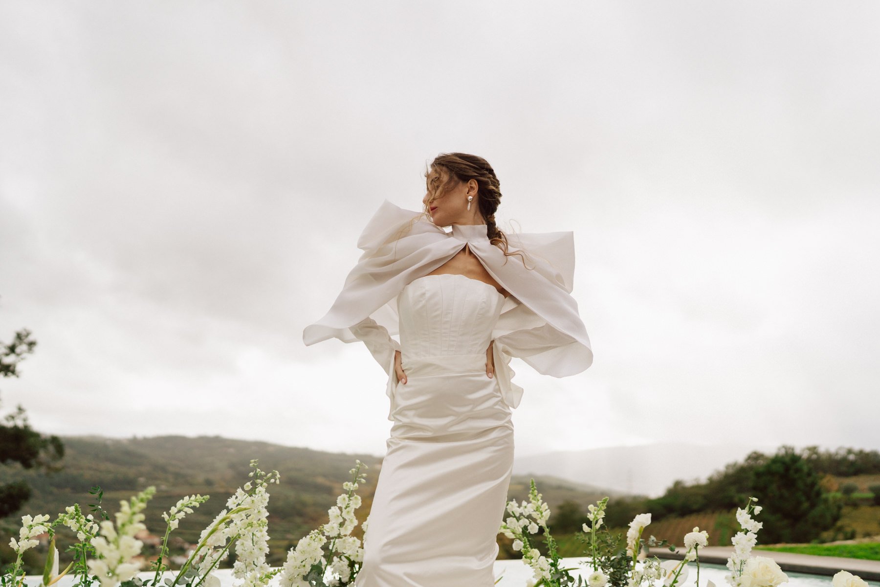 Portrait éditorial d’une mariée portant une robe Alma Real face aux collines de la Quinta do Pinho au Portugal – mariage destination élégant