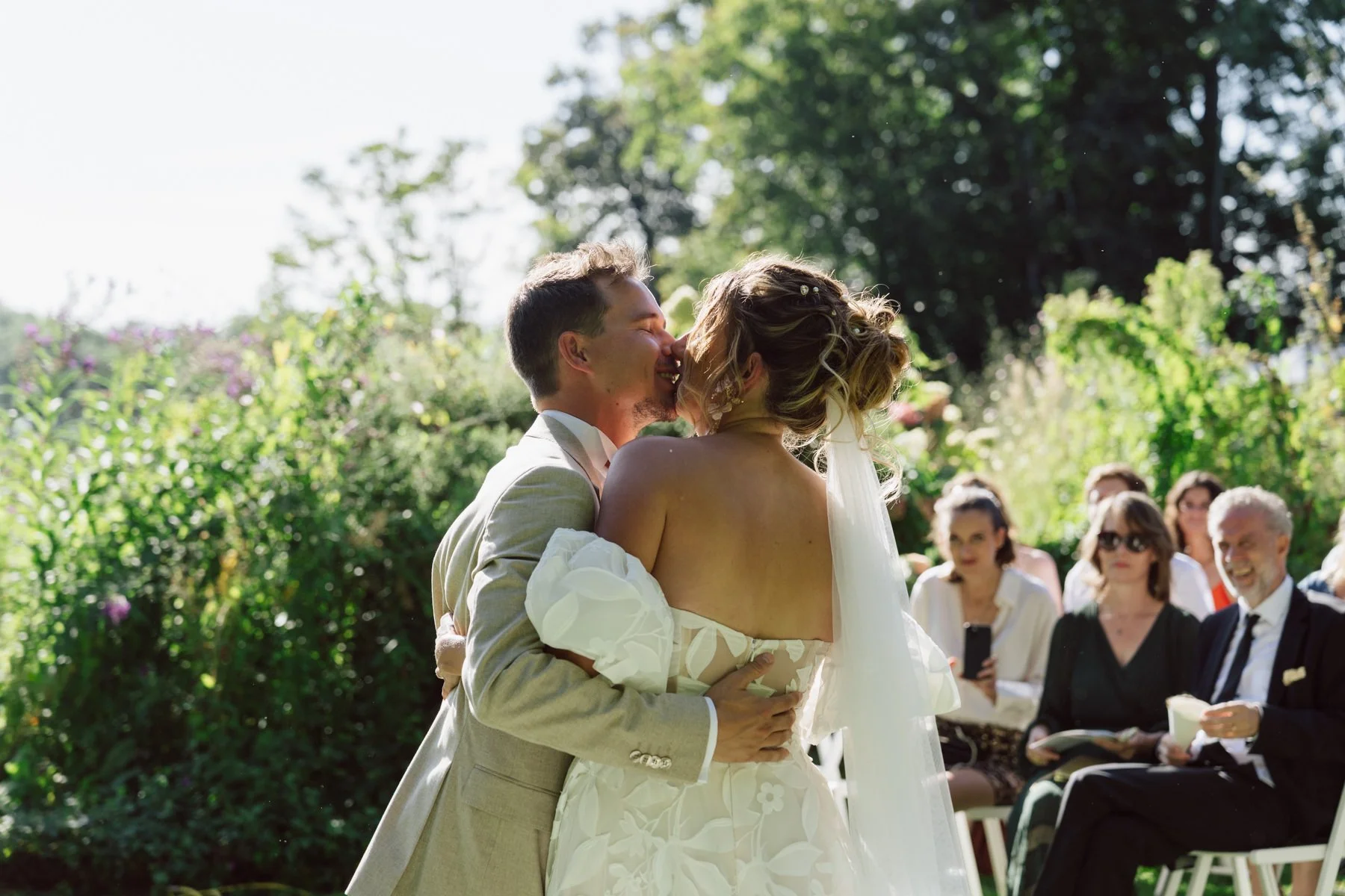 Cérémonie laïque en plein air au Castel de Bois-Genoud, les mariés s’embrassent sous le regard des invités