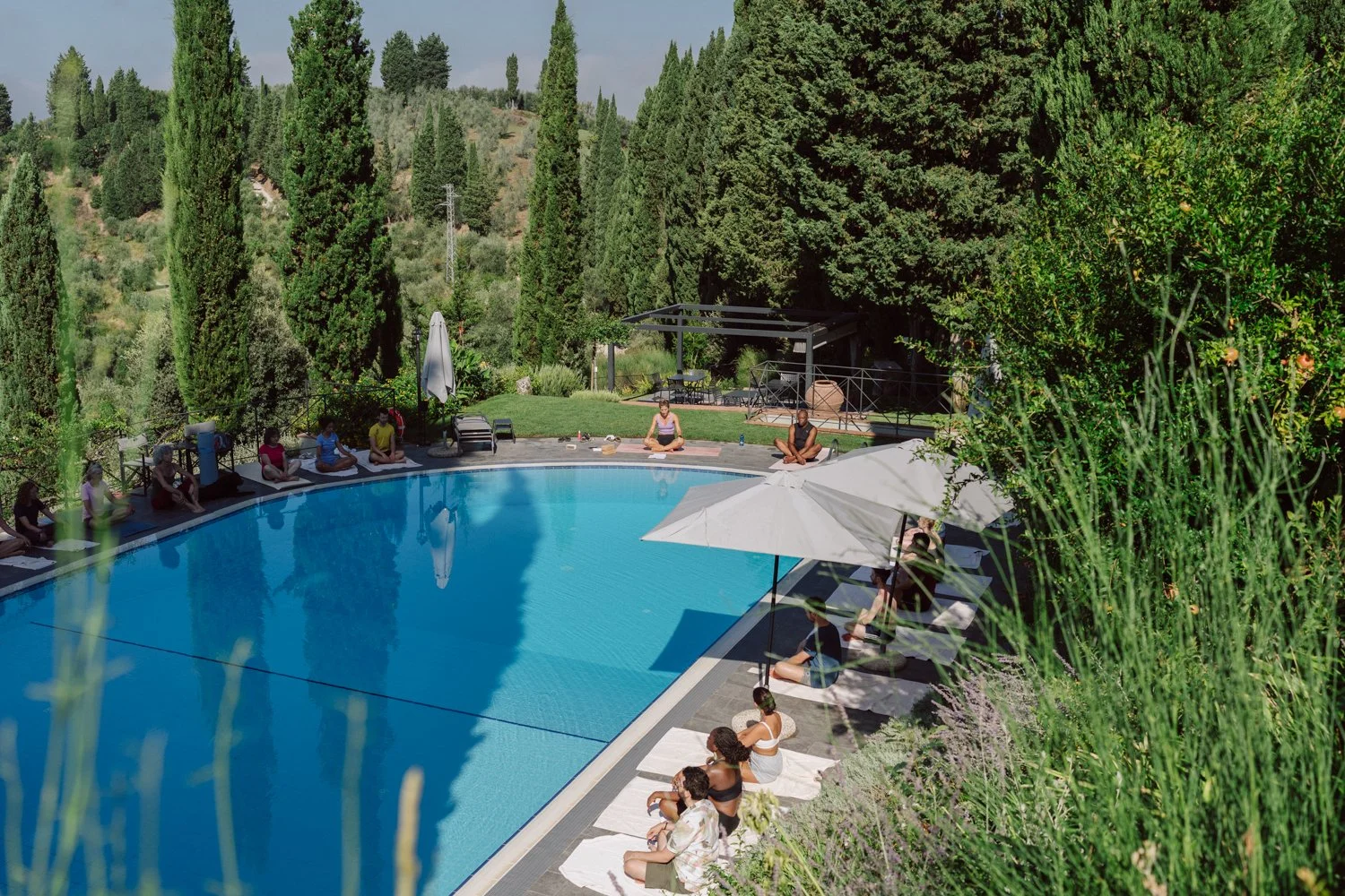 Piscine d’un domaine en Toscane entourée de cyprès et nature, cadre idéal pour un mariage en Italie