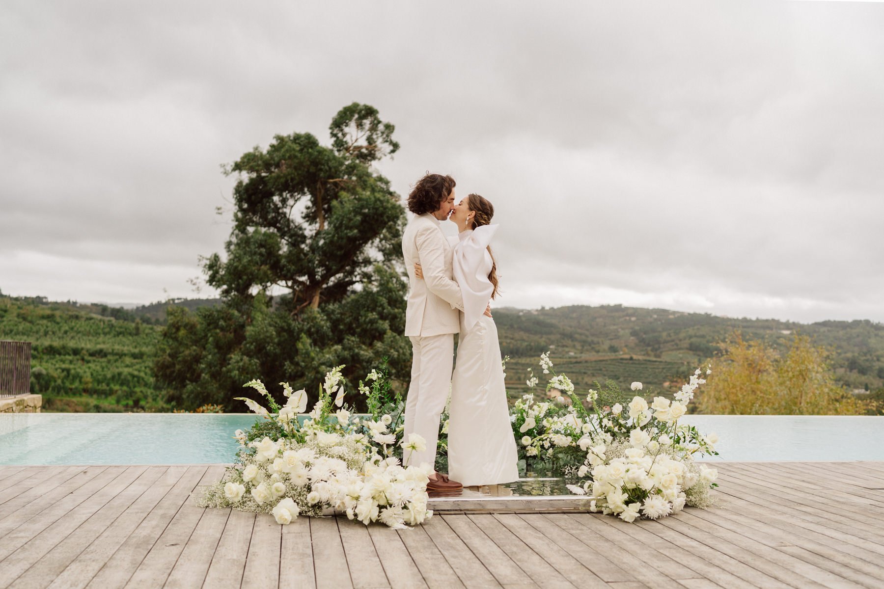 Luxury destination wedding at Quinta do Pinho Portugal with couple portrait by infinity pool and floral installation
