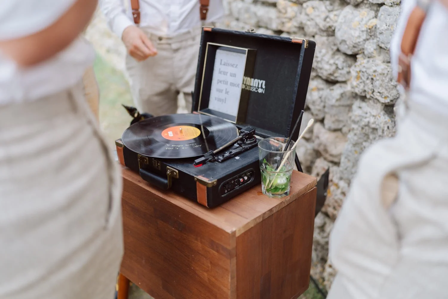 Platine vinyle installée sur une table en bois avec un disque en train de tourner, animation musicale rétro pendant le mariage.