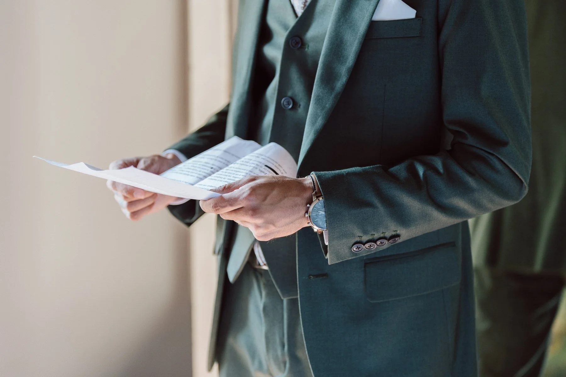 Marié en costume vert lisant son discours pendant les préparatifs du mariage en Toscane, moment intime avant la cérémonie