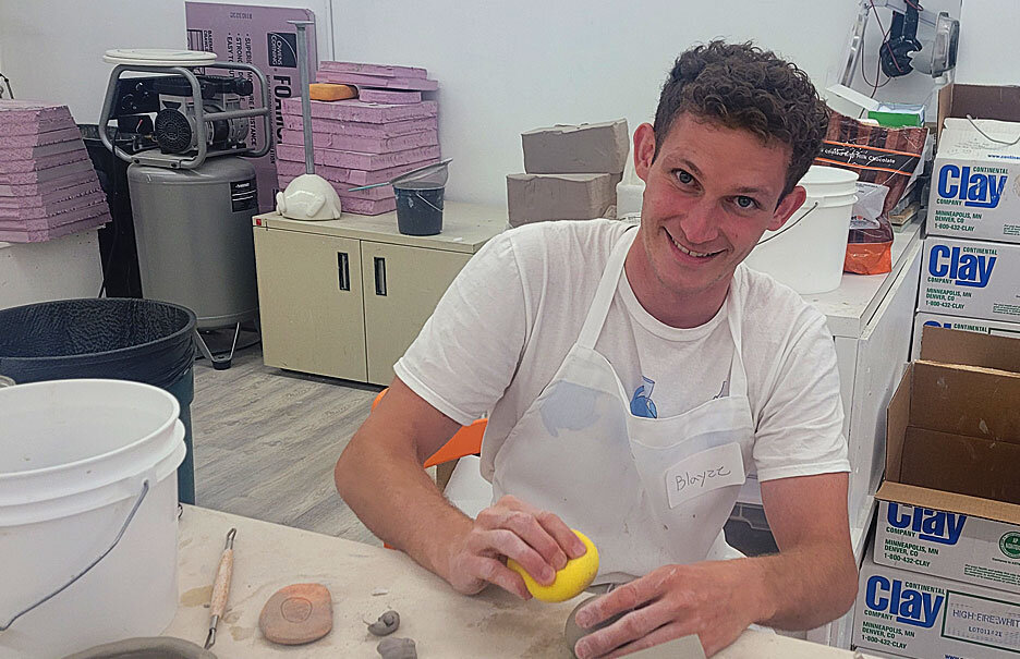   Blayze Buseth working on a clay sculpture.  