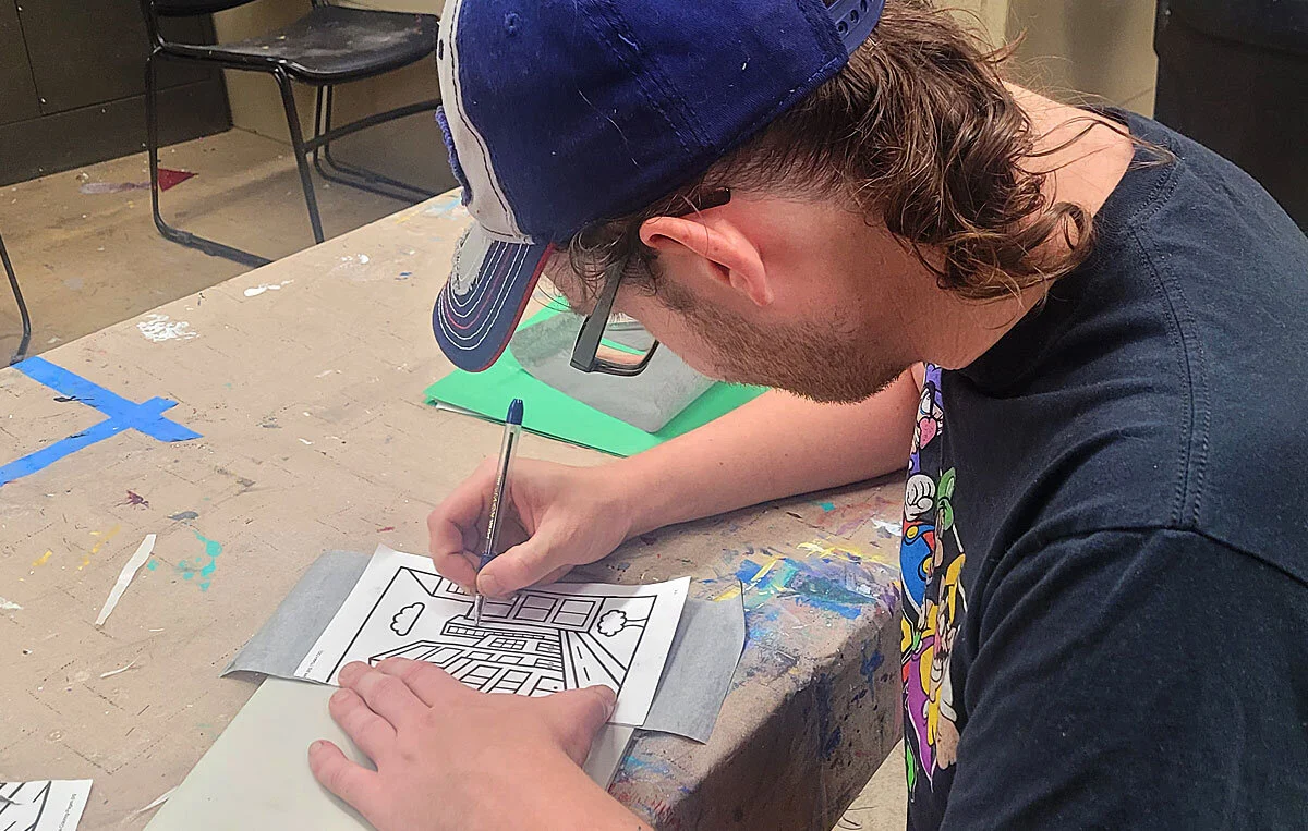 One of the men from Matthew House working on his design in the printmaking class.
