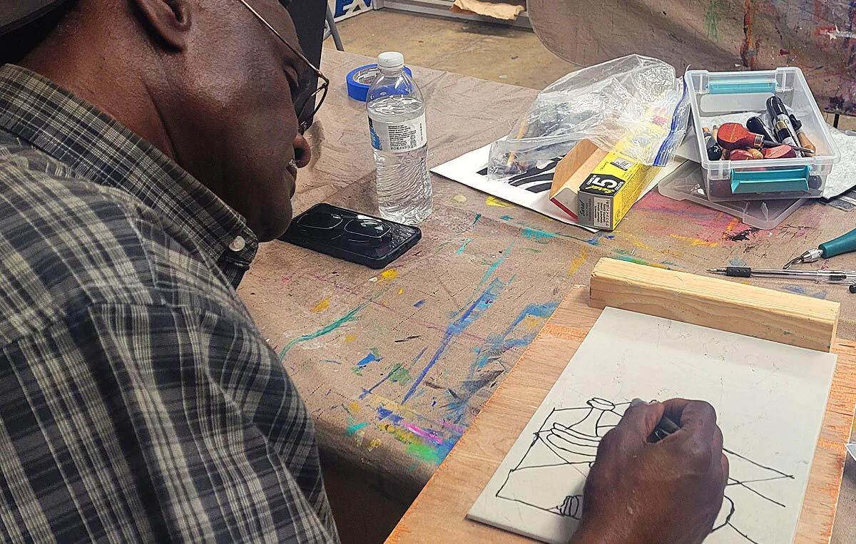 Eddie is working on his design for printmaking class.