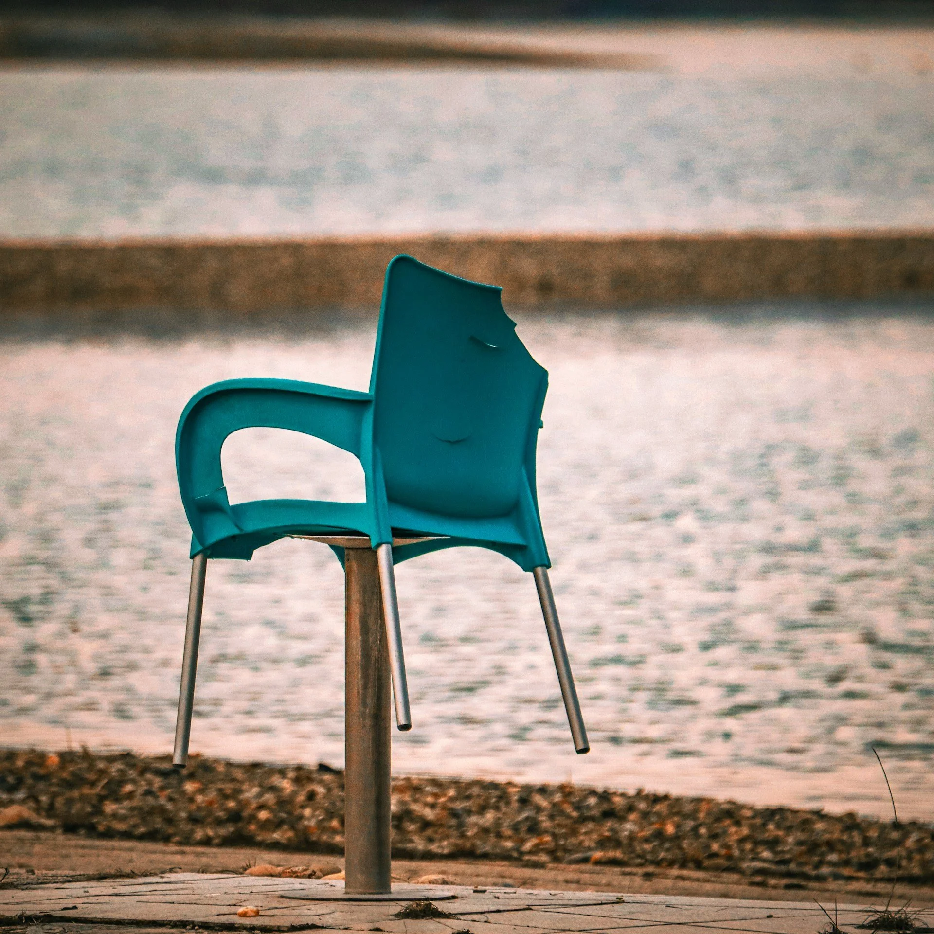 Blue plastic chair with an improvised extension attached to the seat, creating a functional but impractical design.