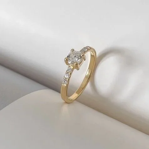 Classic round diamond engagement ring with small diamonds in the ringband 