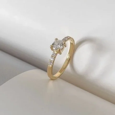 Solitaire diamanten verlovingsring met kleine diamantjes aan de zijkanten. Handgemaakt door duurzame juwelenontwerpster Anneleen De Vree in Antwerpen.