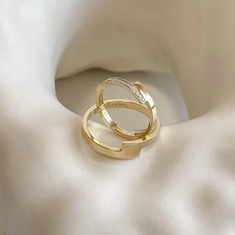 Matching modern wedding rings in Antwerp. Made in recycled gold, hers with an eternity setting of lab diamonds