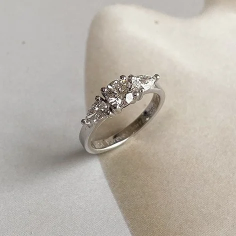 White gold engagement ring with round center diamond and two pear-shaped diamonds. Ethically crafted by a goldsmith in Antwerp.