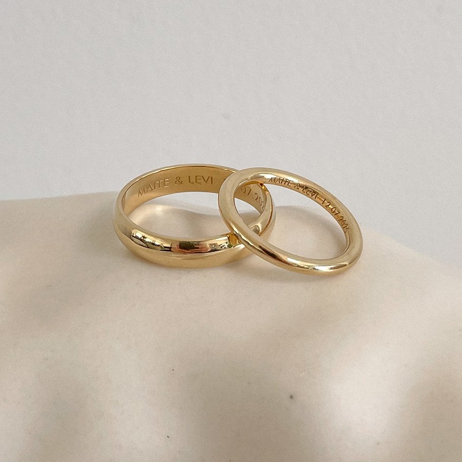 A matching set of minimalist and subtle yellow gold wedding bands