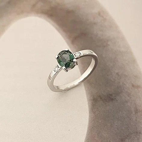 Verlovingsring in witgoud met ovale edelsteen en 2 zijdiamanten, vervaardigd door juwelier De Vree. 