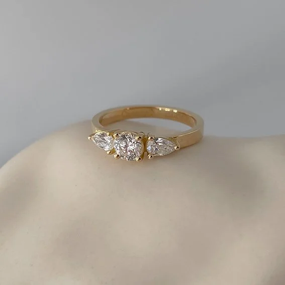 Duurzame verlovingsring met ronde diamant en kleine peer diamanten aan de zijkant. Goudsmid Antwerpen.