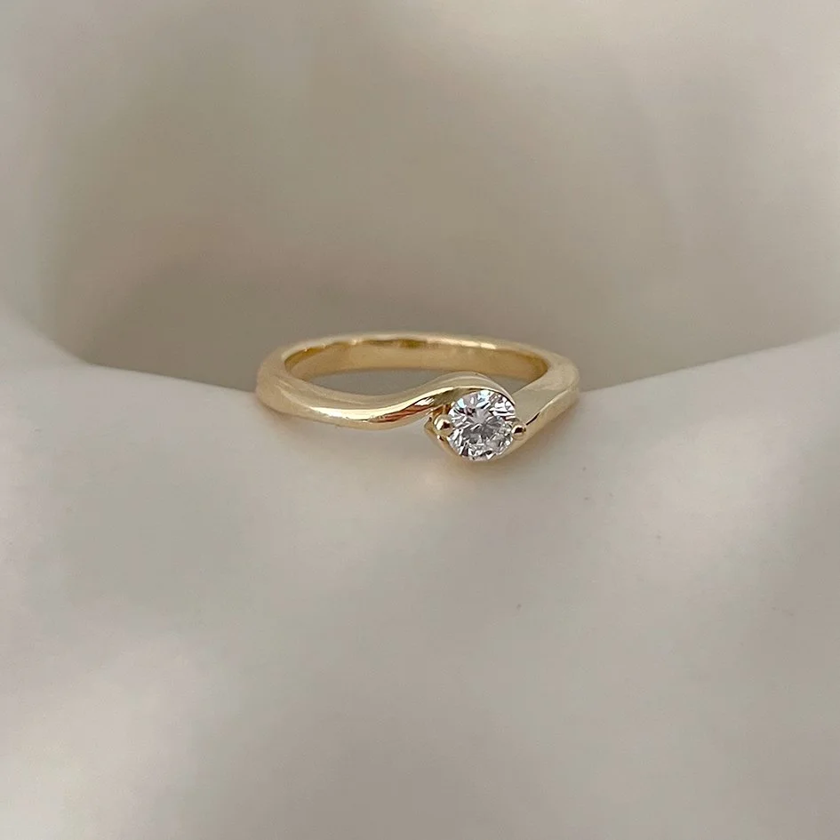 Organic overlap gold engagement ring with a 0.25 carat sustainable lab diamond. Handcrafted in Antwerp.d