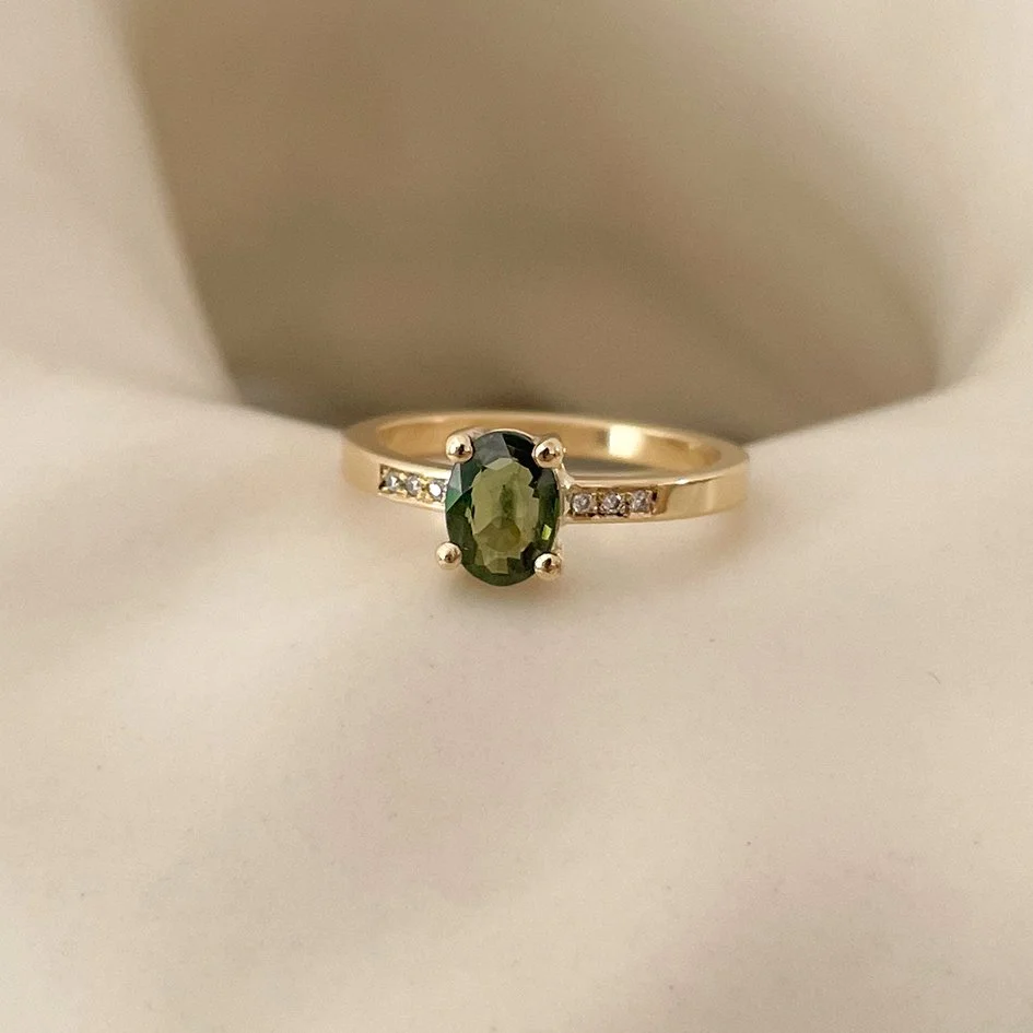 Handcrafted engagement ring featuring a green gemstone and small diamonds, crafted from ethically sourced and sustainable gold