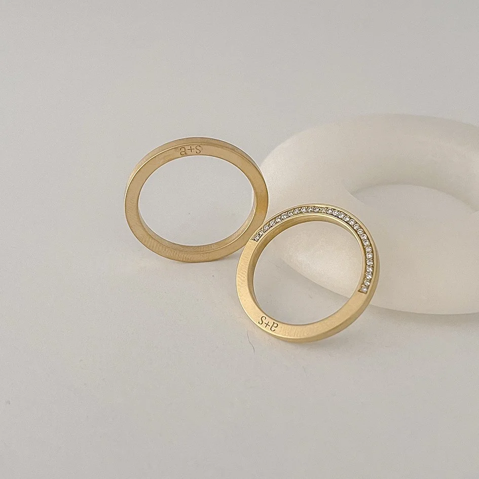 A modern wedding band with diamonds on the sides and a subtle engraving.
