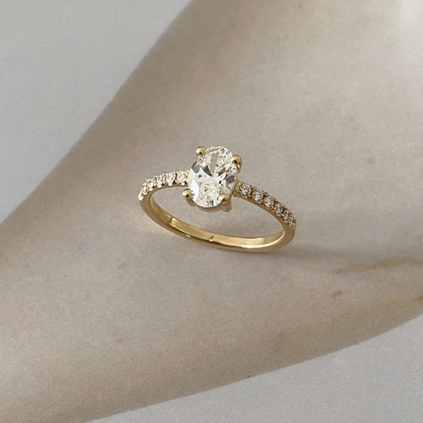 Verlovingsring met grote ovale diamant en kleine diamantjes in de ringband. Handgemaakt in Antwerpen.