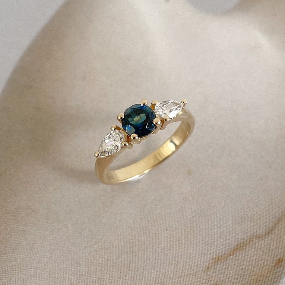 Engagement ring with diamonds and gemstones in sustainable gold.