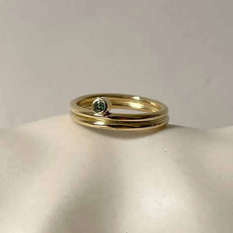Delicate and unusual engagement ring with a small green gemstone