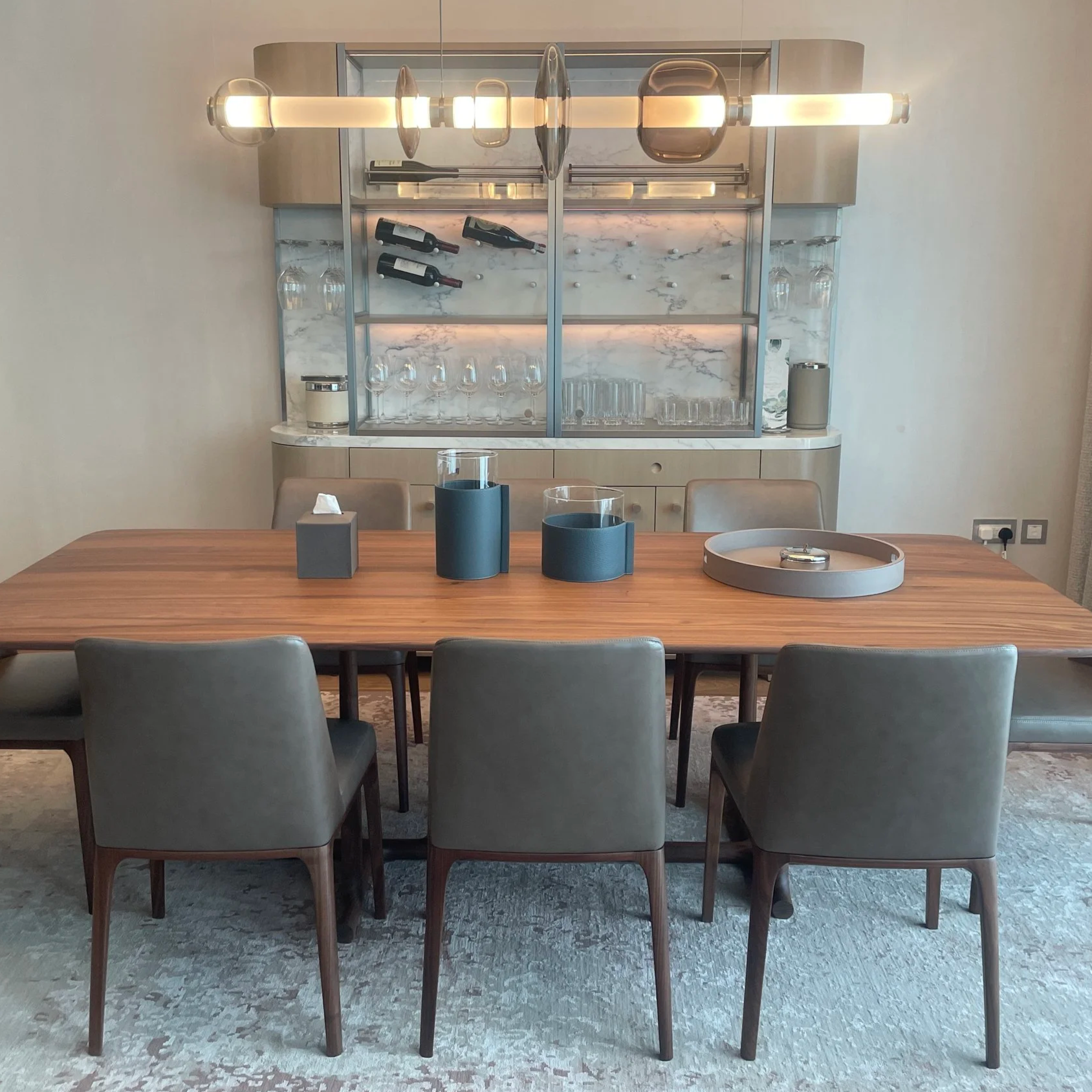 A dining table of a property in dubai, 3 chairs and a wooden table