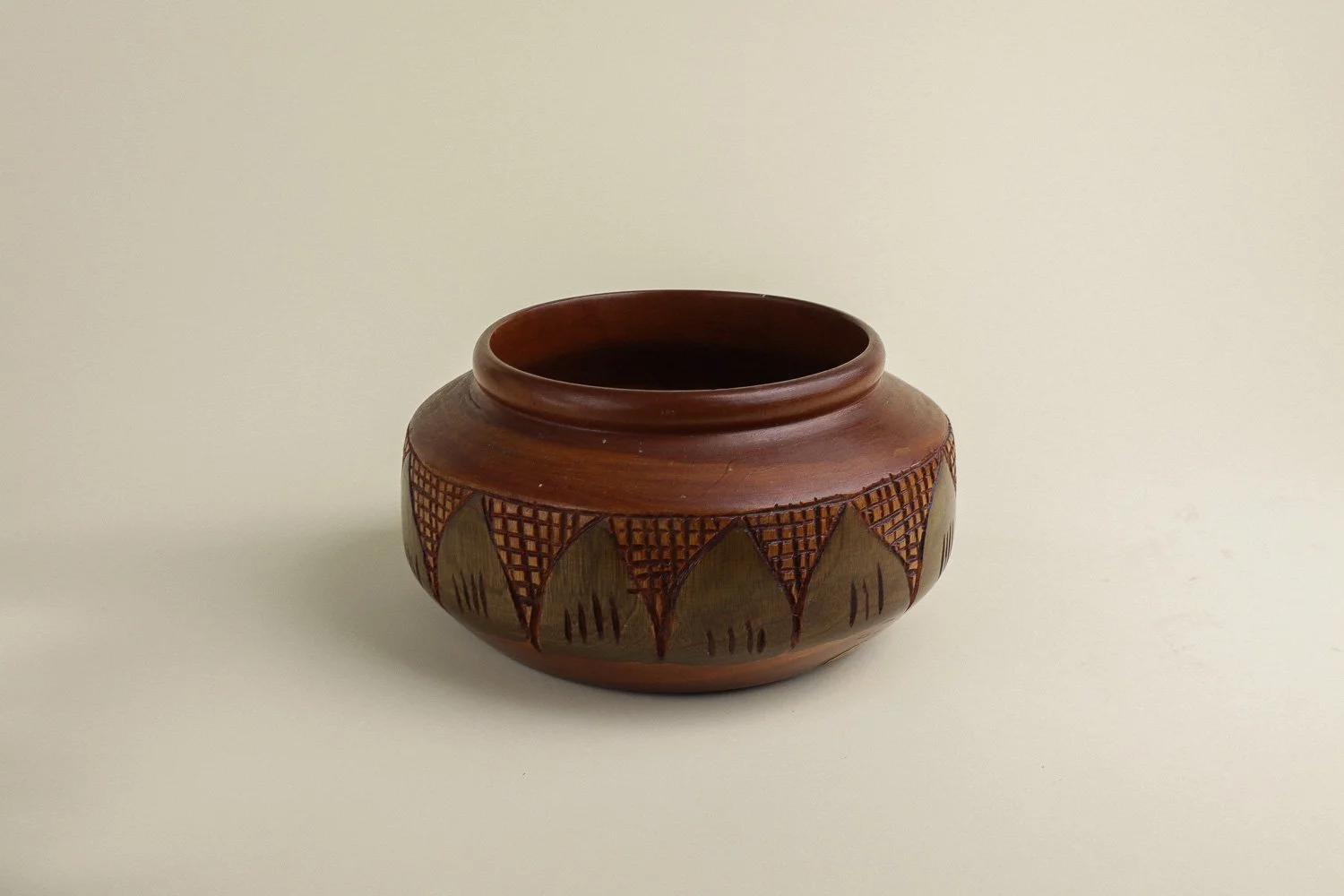 Handmade decorative wooden bowl featuring an intricate crosshatch and leaf pattern.