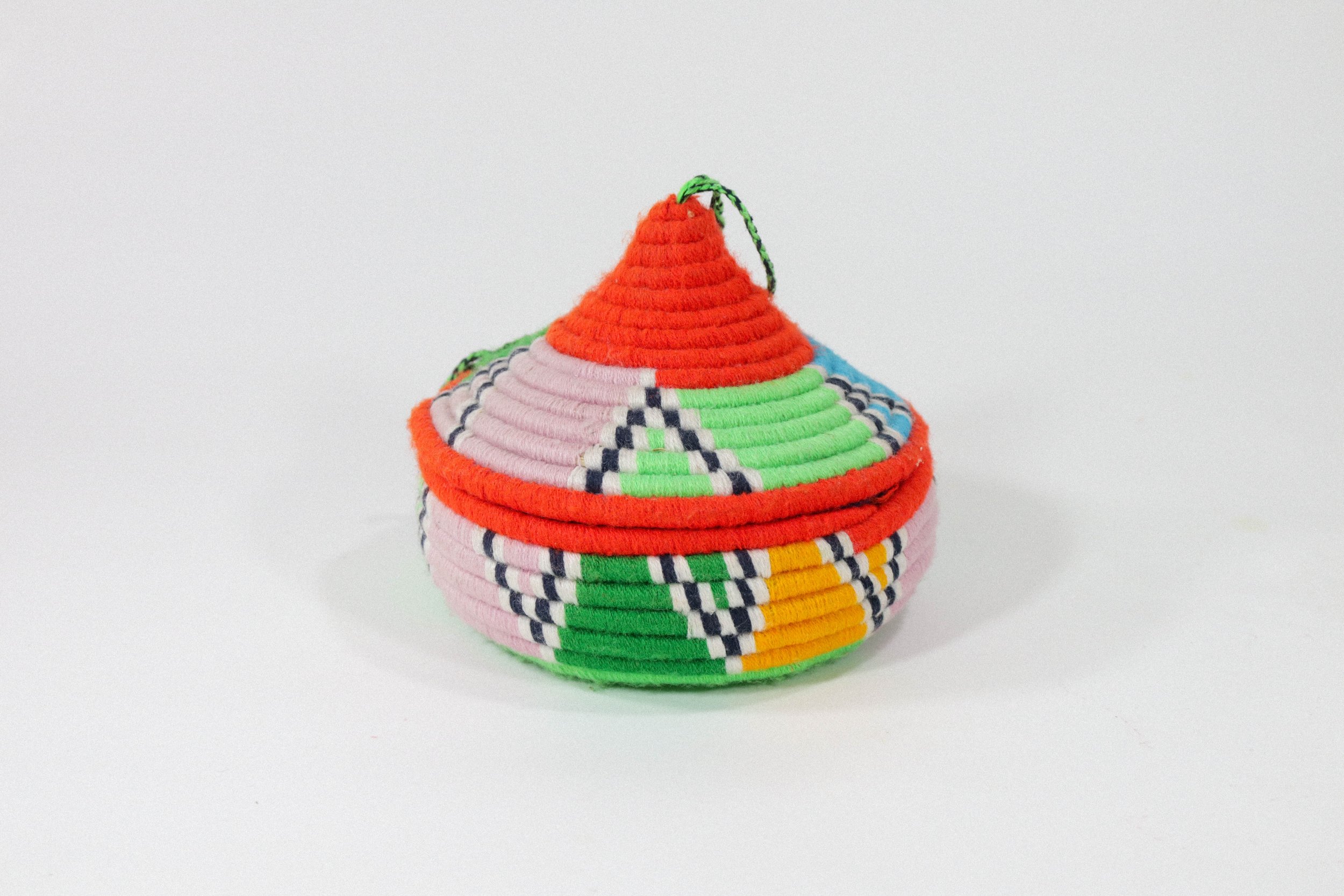 Hand-woven multicolor African hanging basket—a colorful storage solution for anywhere in the house! Lid stays on, even when basket is hung.