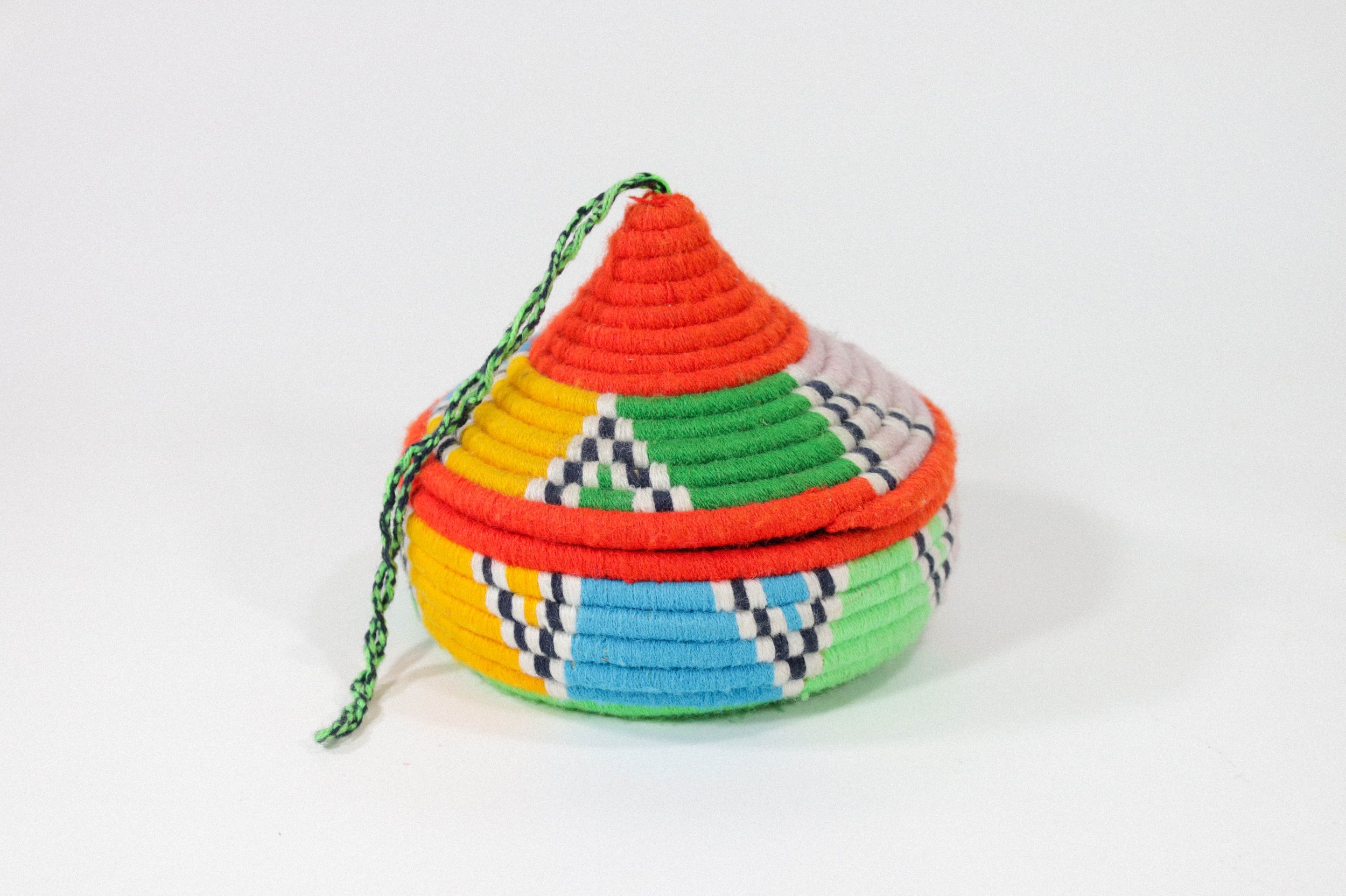 Hand-woven multicolor African hanging basket—a colorful storage solution for anywhere in the house! Lid stays on, even when basket is hung.