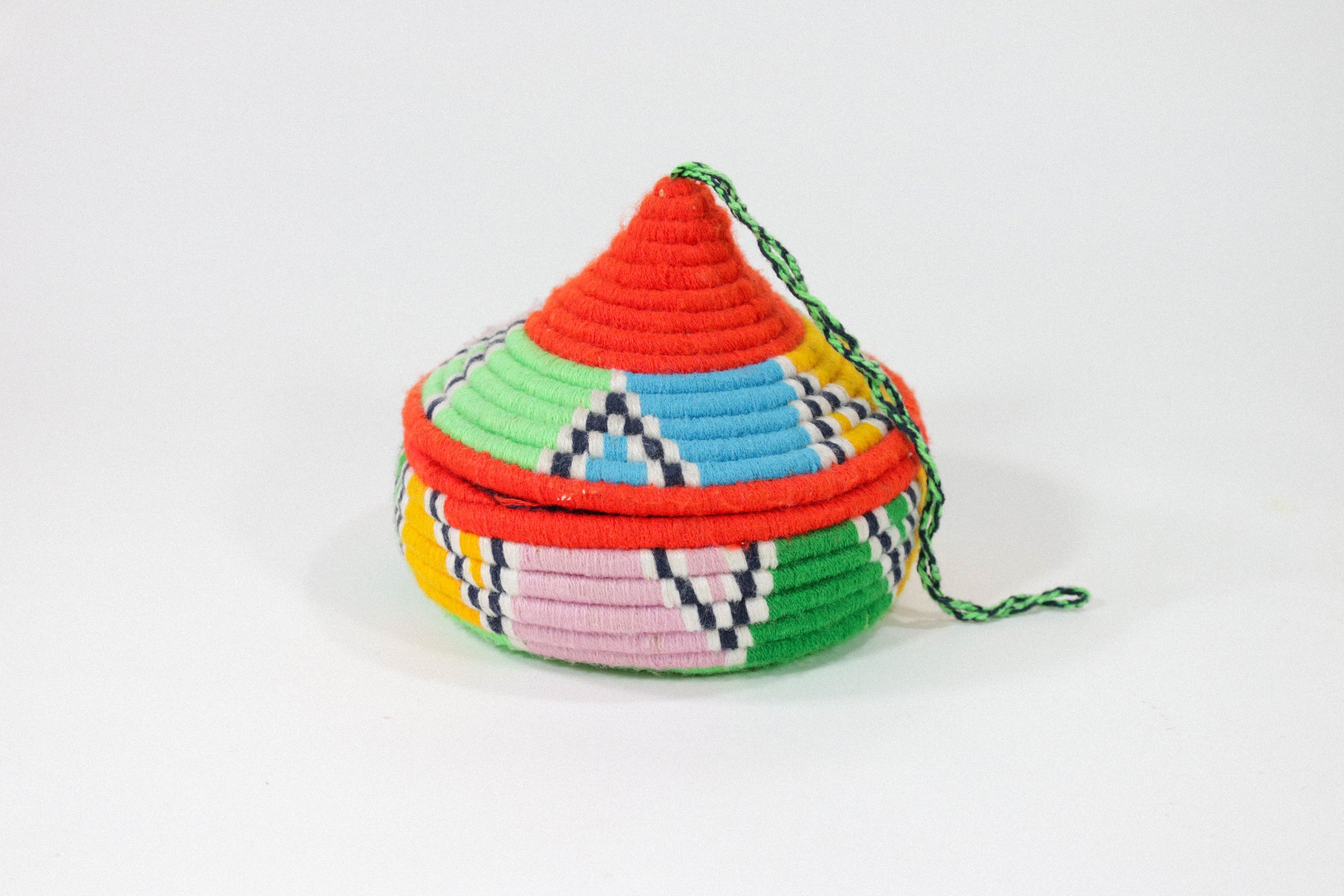 Hand-woven multicolor African hanging basket—a colorful storage solution for anywhere in the house! Lid stays on, even when basket is hung.