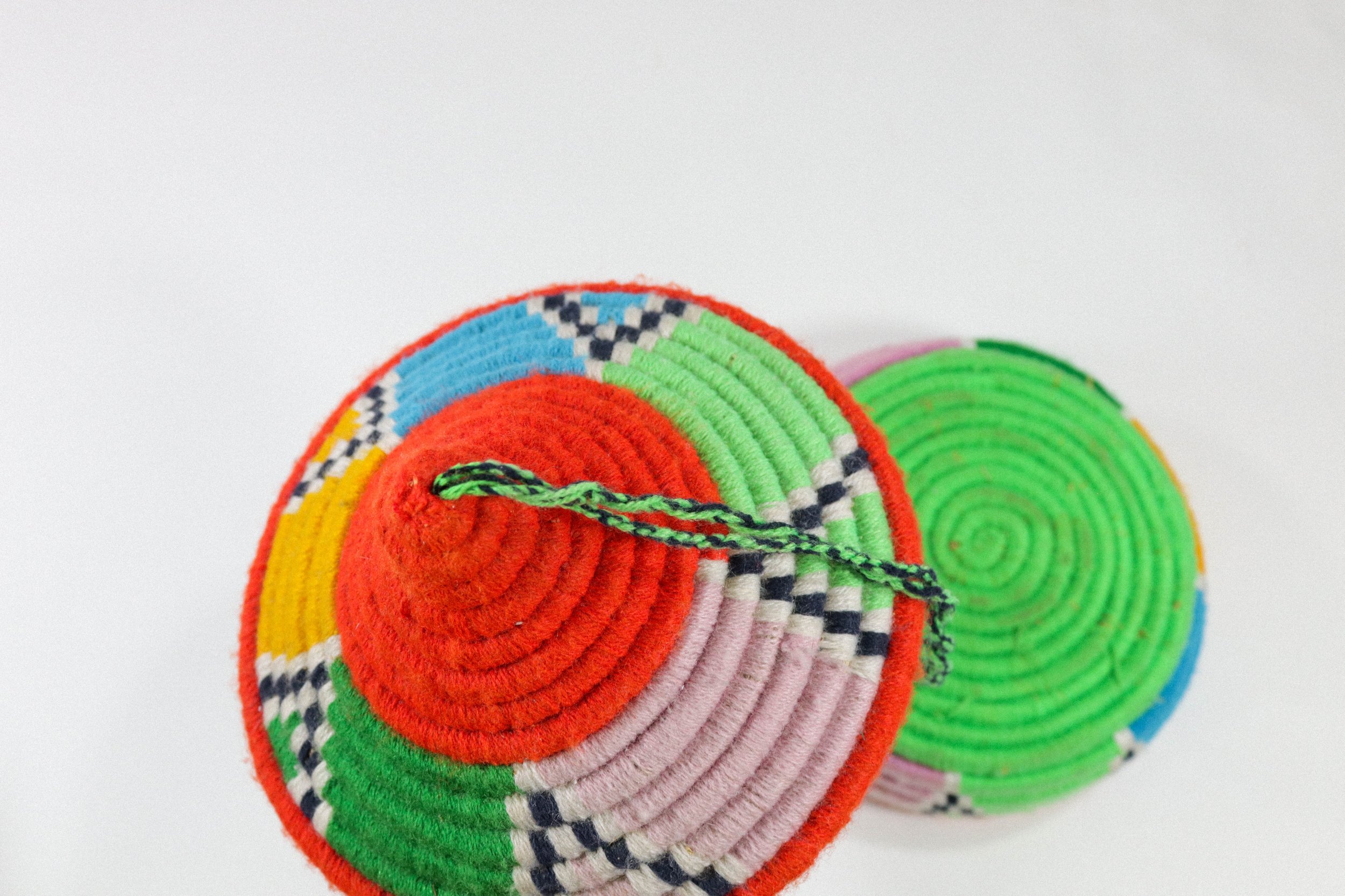 Hand-woven multicolor African hanging basket—a colorful storage solution for anywhere in the house! Lid stays on, even when basket is hung.