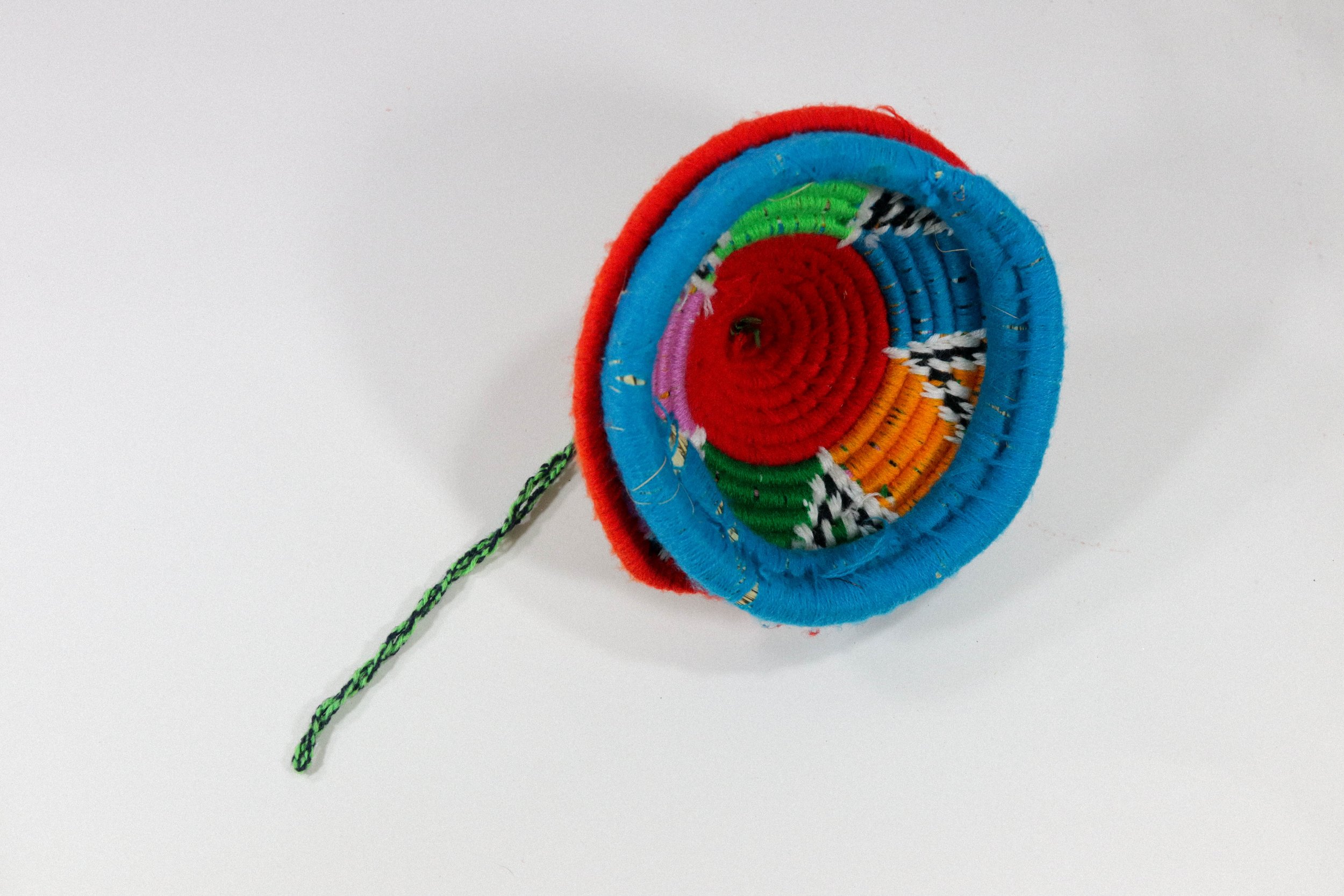 Hand-woven multicolor African hanging basket—a colorful storage solution for anywhere in the house! Lid stays on, even when basket is hung.